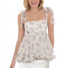 Woman wearing a floral top with sheer sleeves 