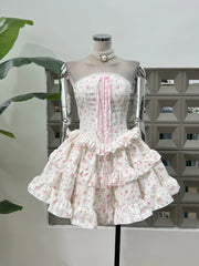 White dress with pink floral pattern on a mannequin against a neutral background
