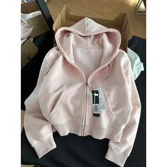 Pink hoodie with a tag on a black surface