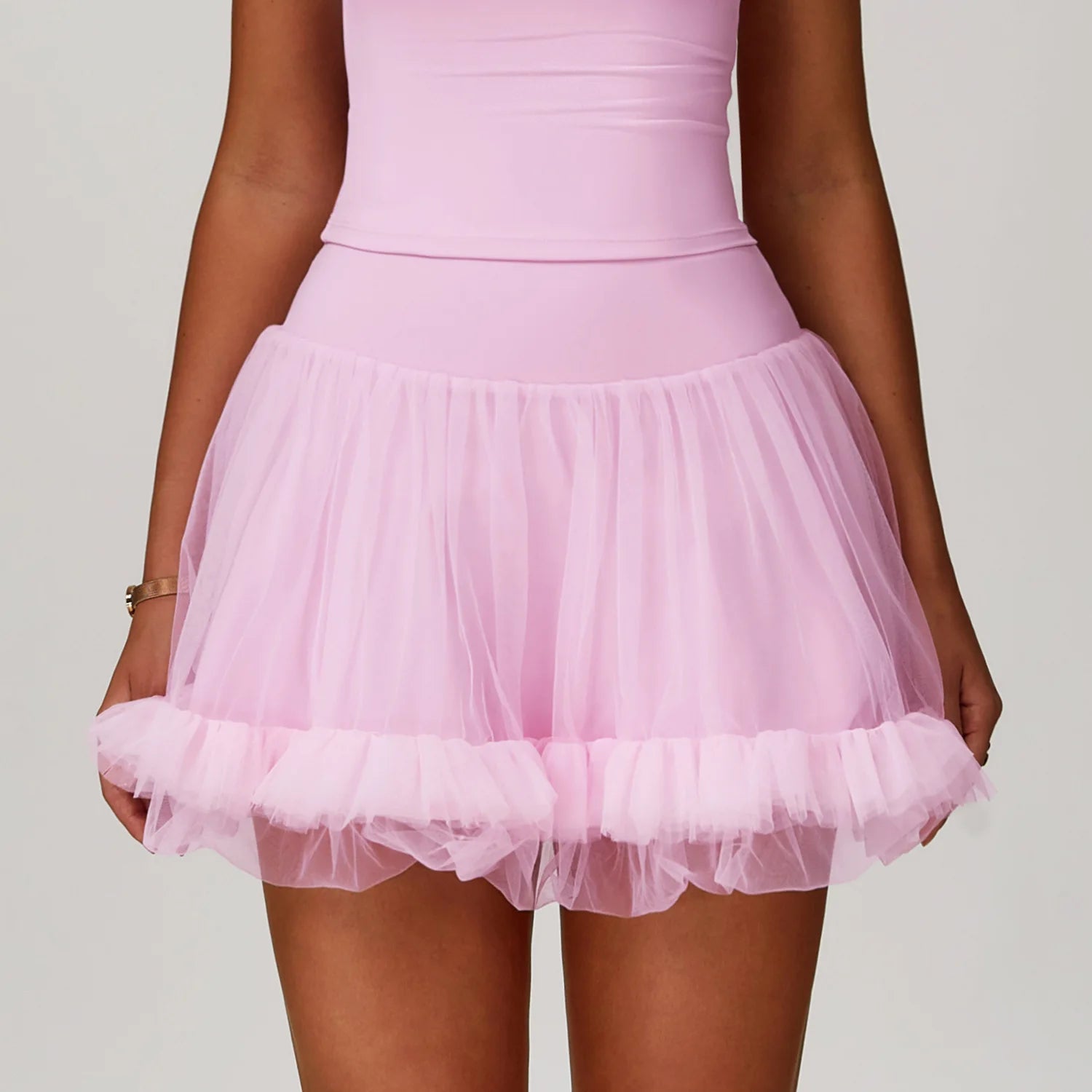 Pink tulle skirt worn by a person on a plain background