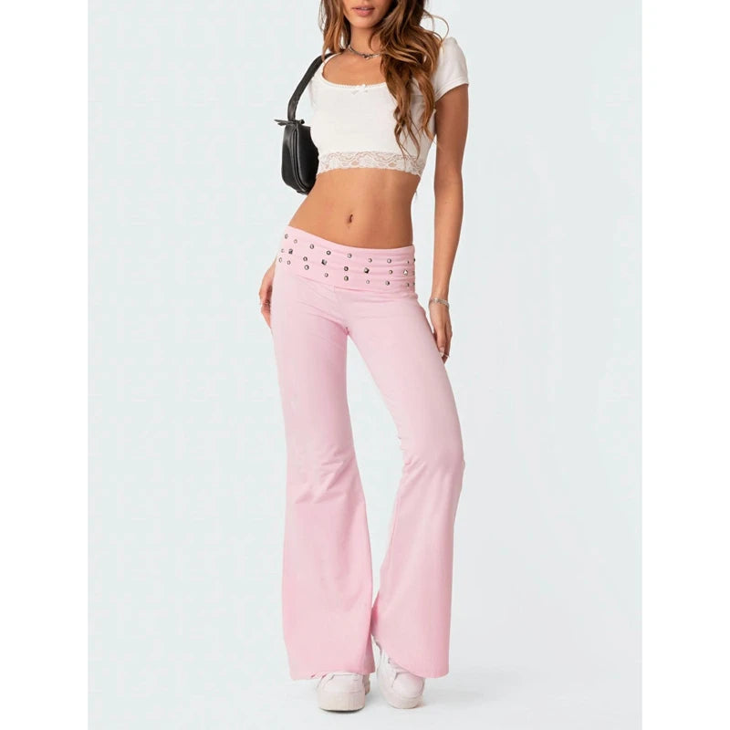 Person wearing a white crop top and pink flared pants 