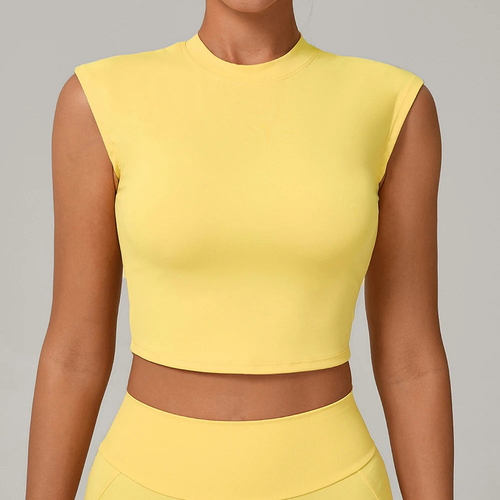 Person wearing a yellow sleeveless top against a gray background