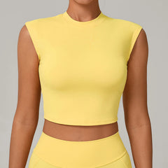 Person wearing a yellow sleeveless top against a gray background