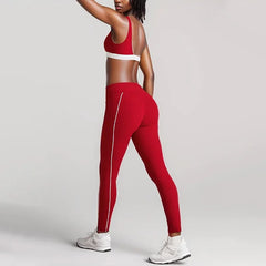 Person wearing a red sports bra and leggings with white accents- side view