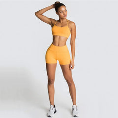 Person wearing a yellow sports bra and shorts set on a white background