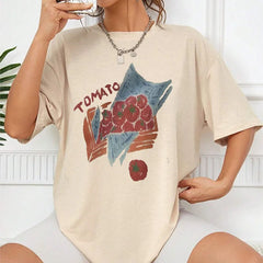 Person wearing a beige t-shirt with a graphic design of tomatoes and leaves.
