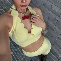 Person wearing a yellow dress with a textured pattern against a tiled wall.