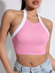 Pink sports bra with white trim worn by a person- close view