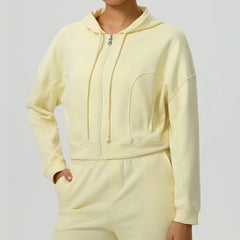 Light yellow hoodie and pants set on a plain background