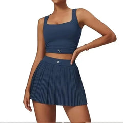 Woman wearing a blue athletic top and pleated skirt on a white background