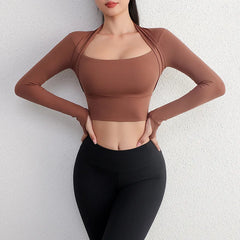 Person wearing a brown long-sleeve top and black leggings