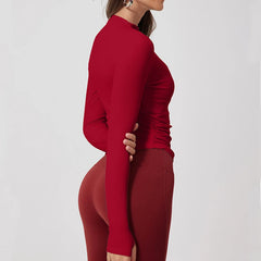 Person wearing a red long-sleeve top and leggings on a light gray background