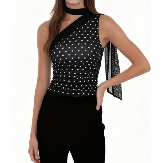 Woman wearing a black polka dot top with a white background