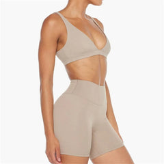 Beige sports bra and shorts set on a white background