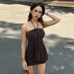 A woman wearing a flattering brown dress with puff sleeves and a halter neck, perfect for a summer party.