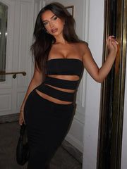 A woman wearing an elegant black tube dress with a flattering fit and a daring slit, perfect for a special occasion.