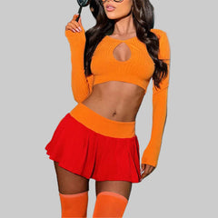 Woman in orange top and red skirt standing in front of a colorful car.