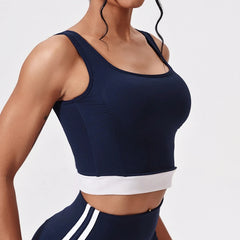 Navy blue sports bra with white trim on a plain background