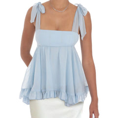 Light blue sleeveless top with ruffled hem and bow straps worn by a person 