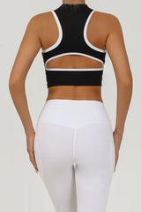 A woman wearing a black athletic crop top with a cutout back design.