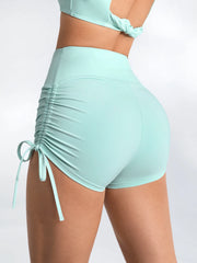 A woman posing in high-waist gym shorts, highlighting their snug fit.