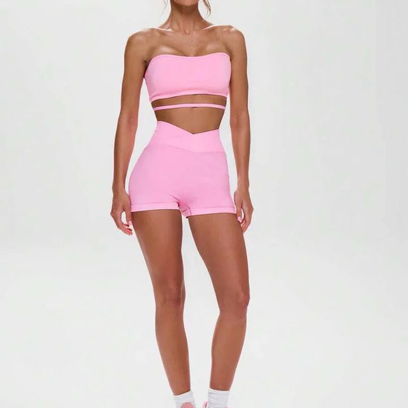 A woman wearing a pink seamless off-shoulder athletic set.
