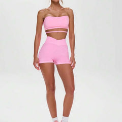 A woman wearing a pink seamless off-shoulder athletic set.