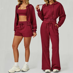 A woman wearing a burgundy athletic shorts and zip hoodie set.